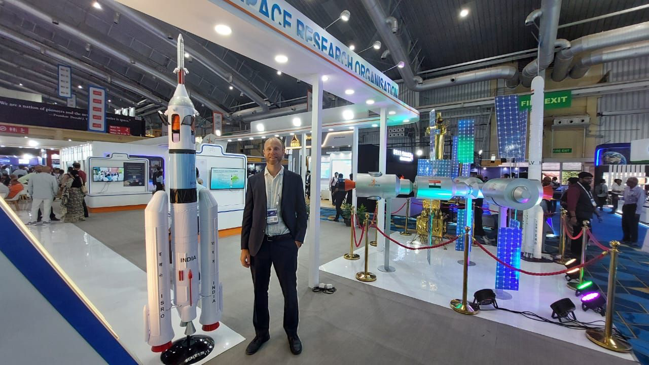 A mission participant at the Indian Space Research Organisation exhibition stand, alongside launch vehicle and orbital infrastructure models. Photograph supplied by SSIP.